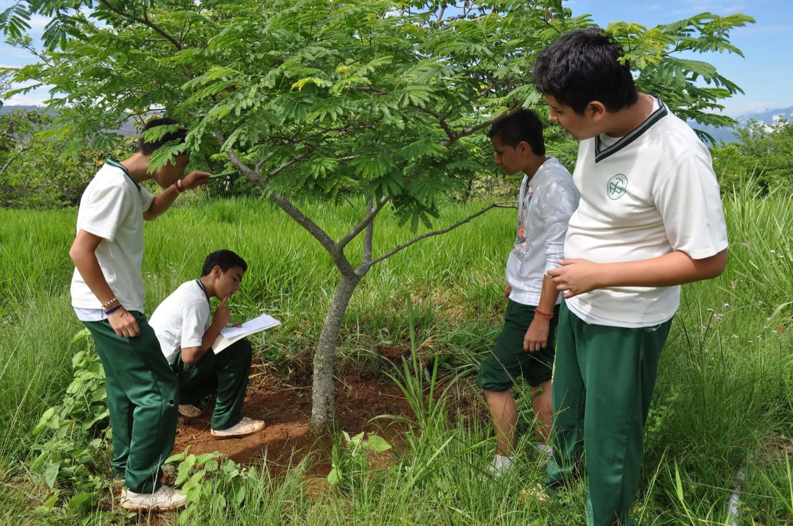 Estudiantes observando un árbol en el Bioparque Móncora