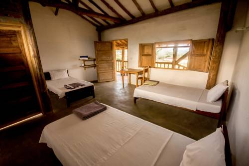 Habitación con dos camas, techo de madera y ventana al campo