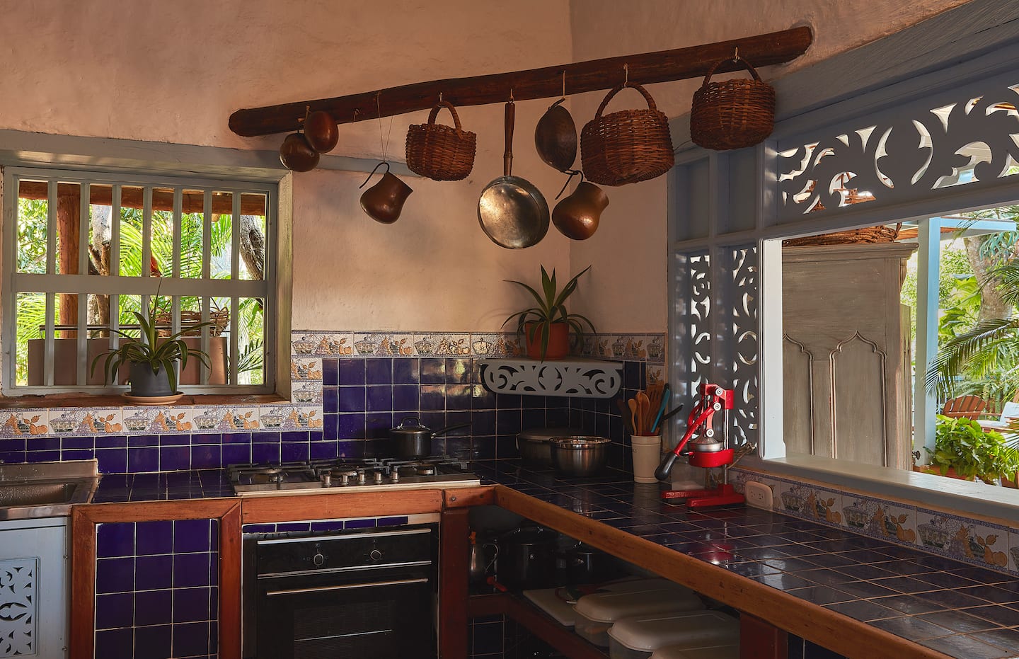 Cocina con baldosas azules y ollas de cobre