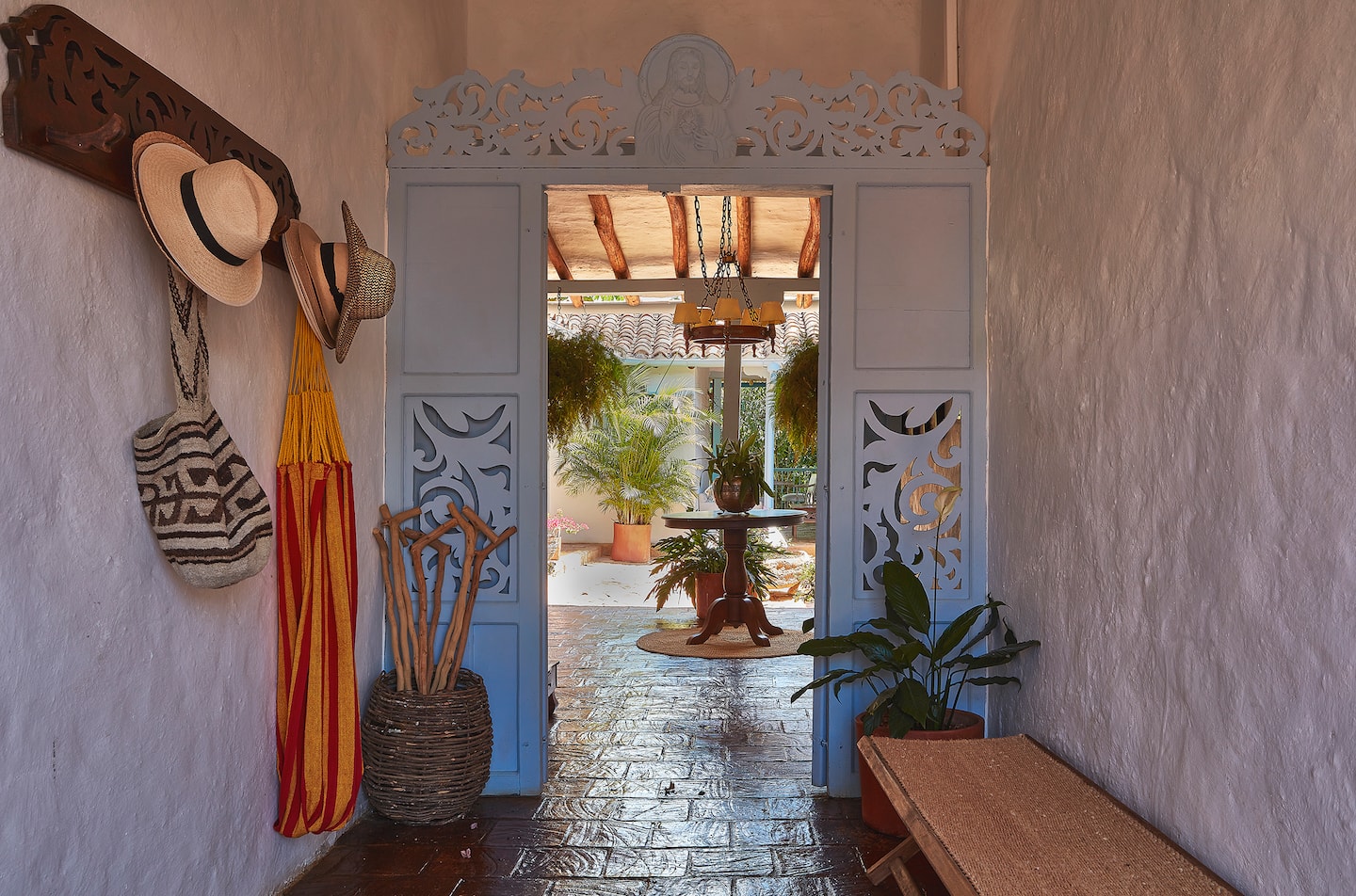 Entrada con arco blanco, mochilas y sombreros colgados