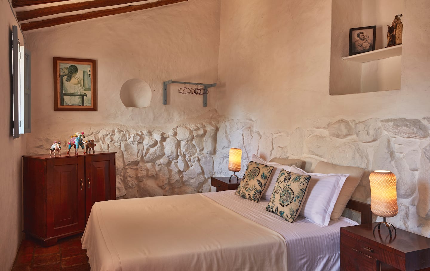 Habitación con muro de piedra y cojines bordados