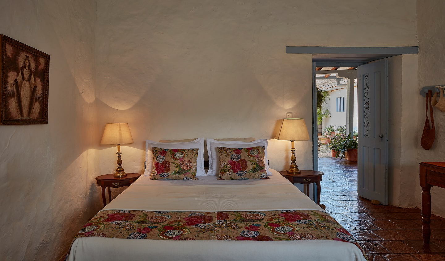 Habitación con cama doble y camino de flores