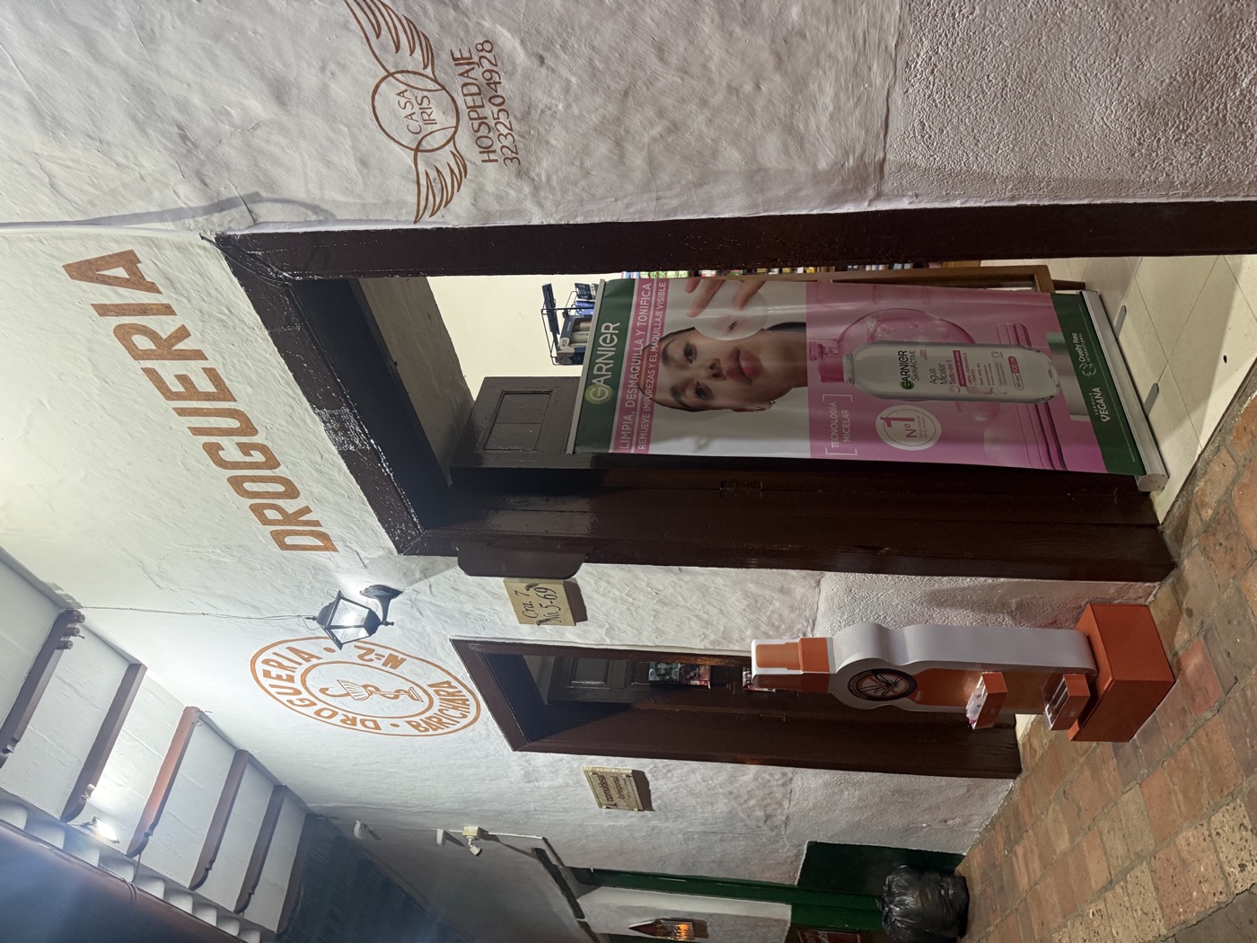 Entrada de la Droguería Barichara con su letrero sobre la pared blanca