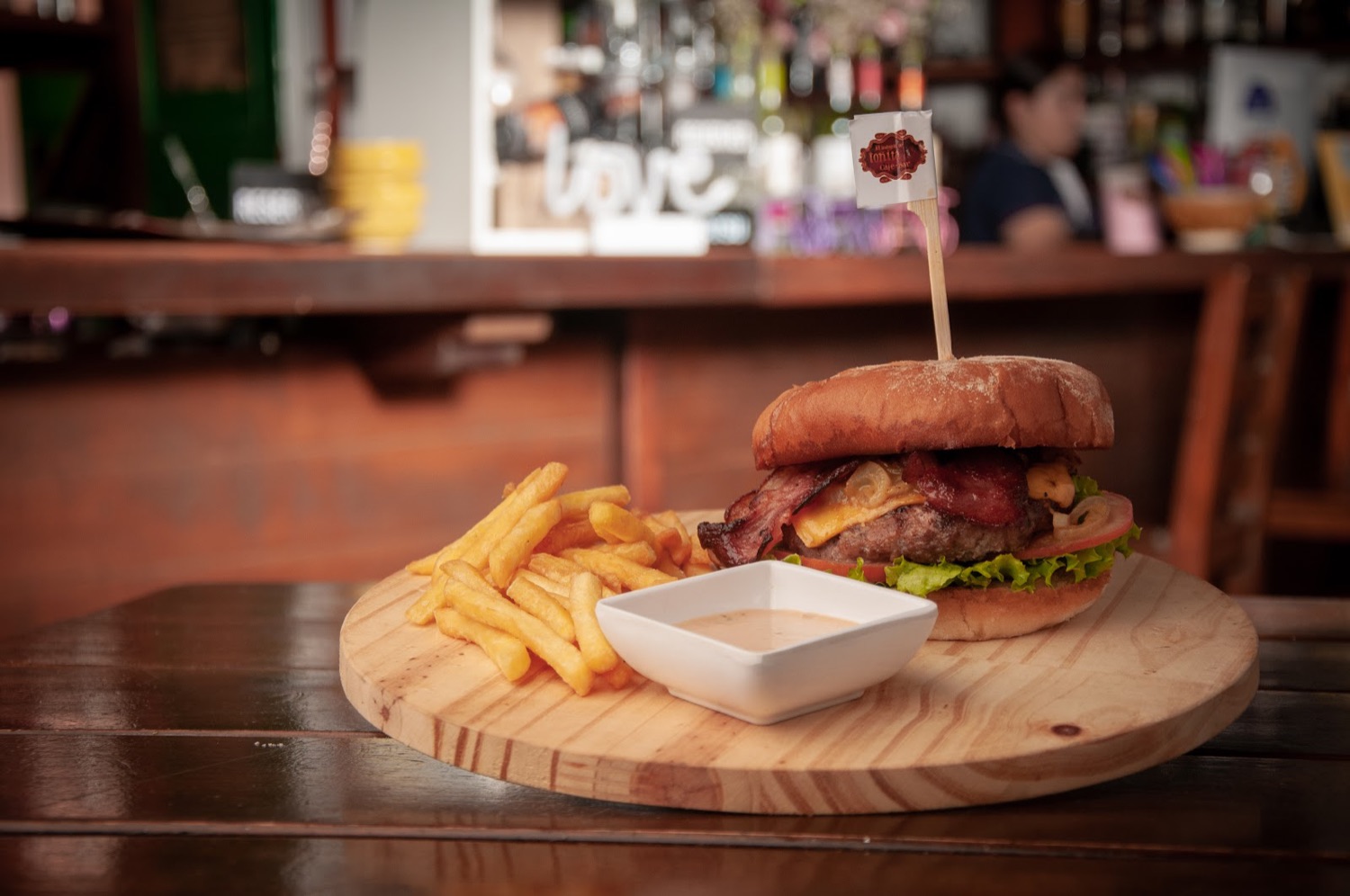 Hamburguesa con papas a la francesa en tabla de madera