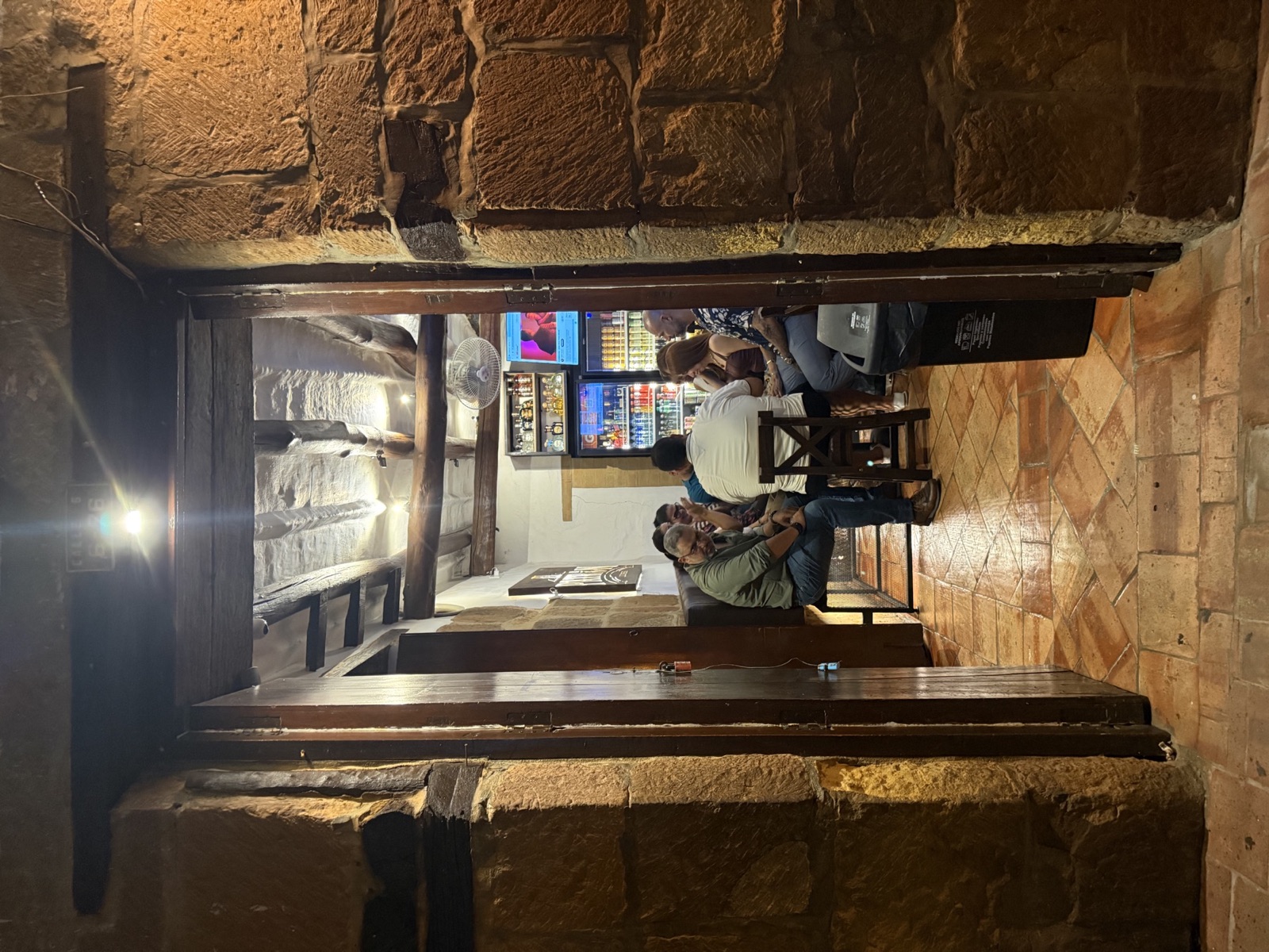 Corredor de piedra iluminado que lleva al bar