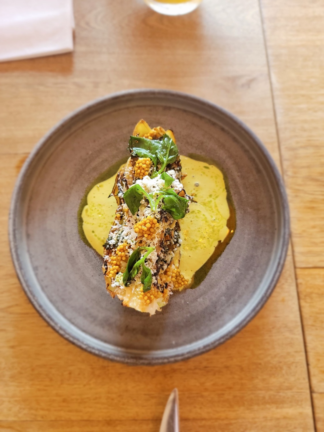 Plato con crema amarilla y hierbas
