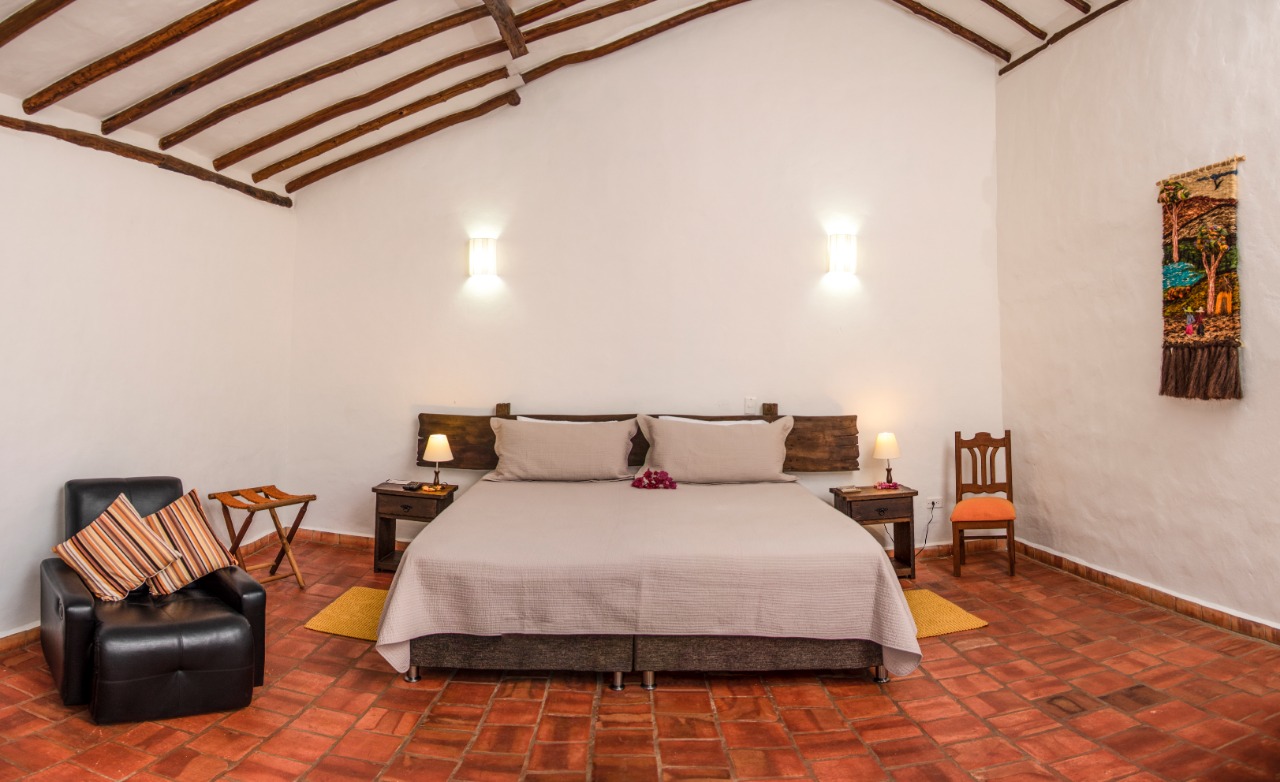 Habitación con cama doble y piso de barro