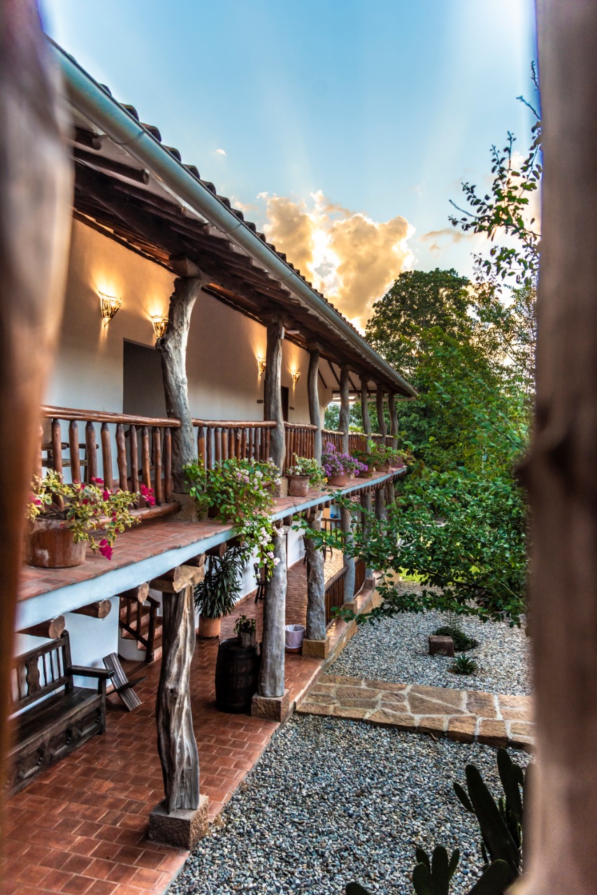 Corredor colonial con barandas de madera y flores