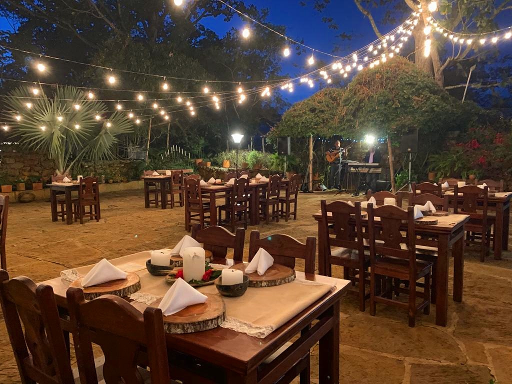 Mesas en el jardín bajo luces colgantes de noche