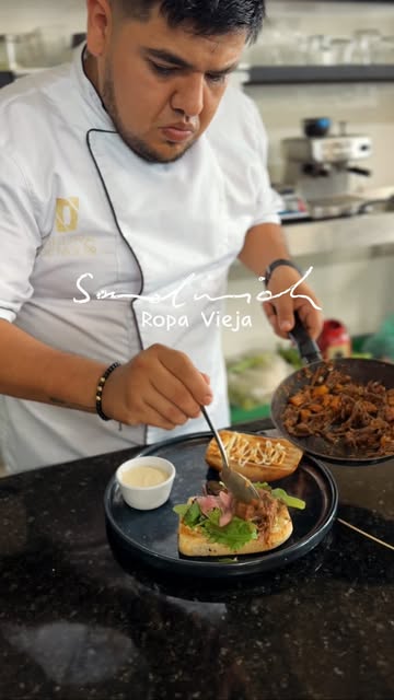 El chef sirviendo ropa vieja en la cocina del hotel
