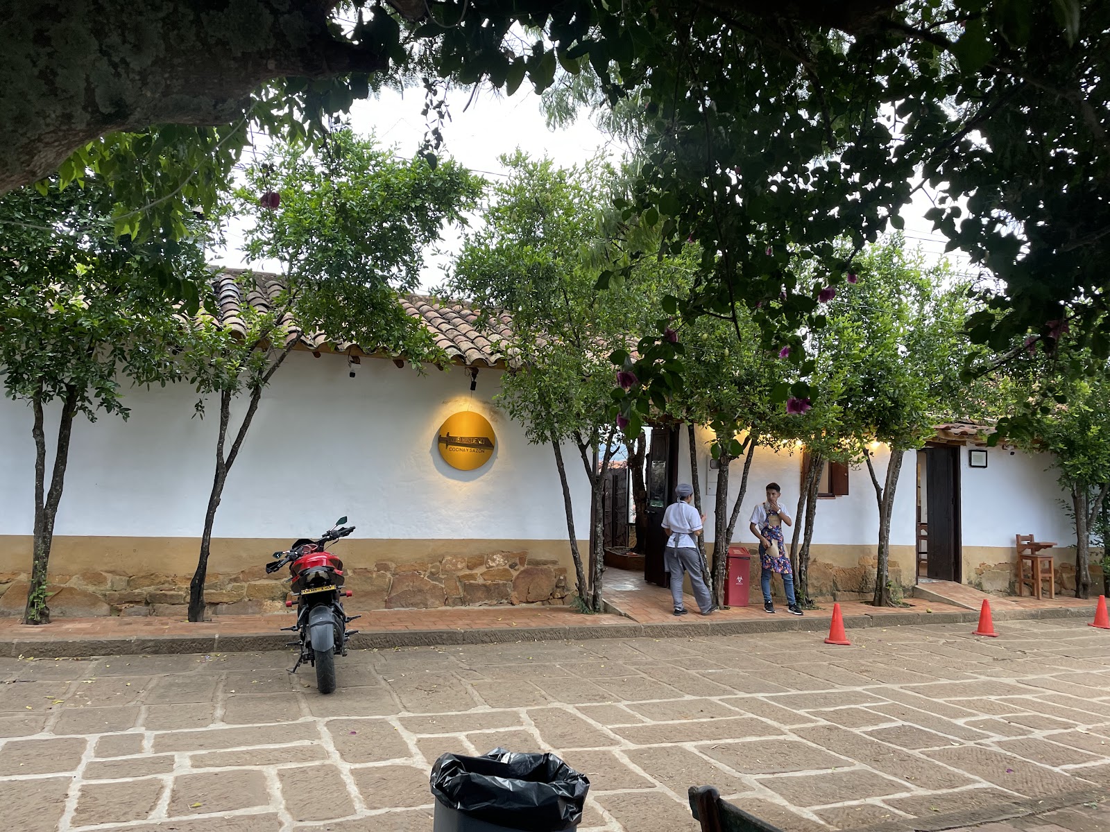 La entrada del restaurante, casa blanca con árboles