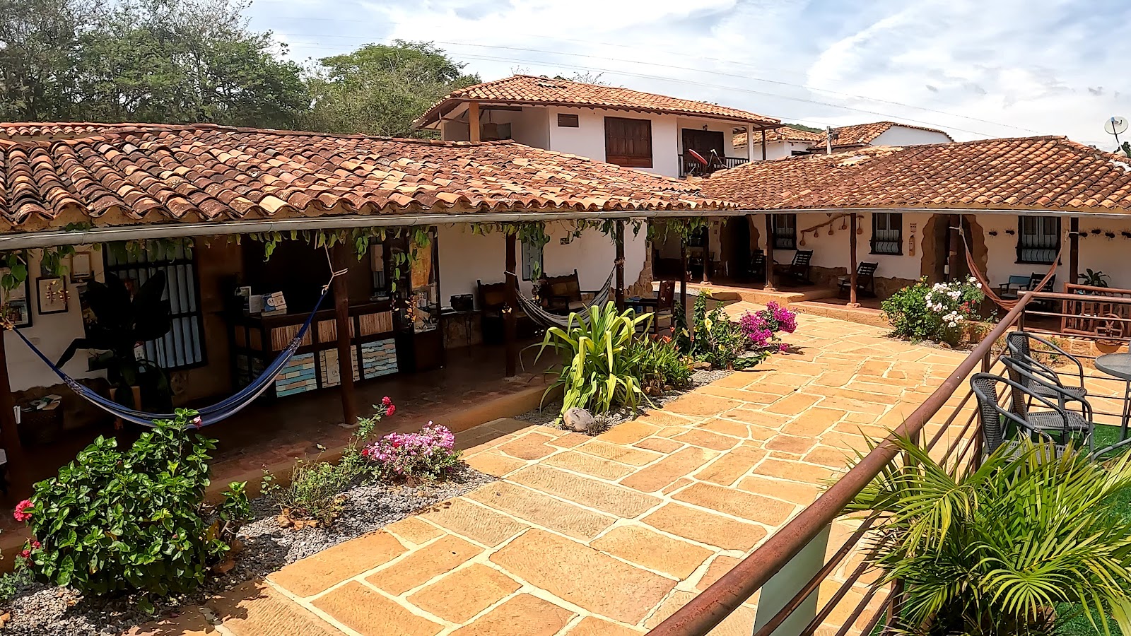 Corredores de teja con hamacas y jardín florido