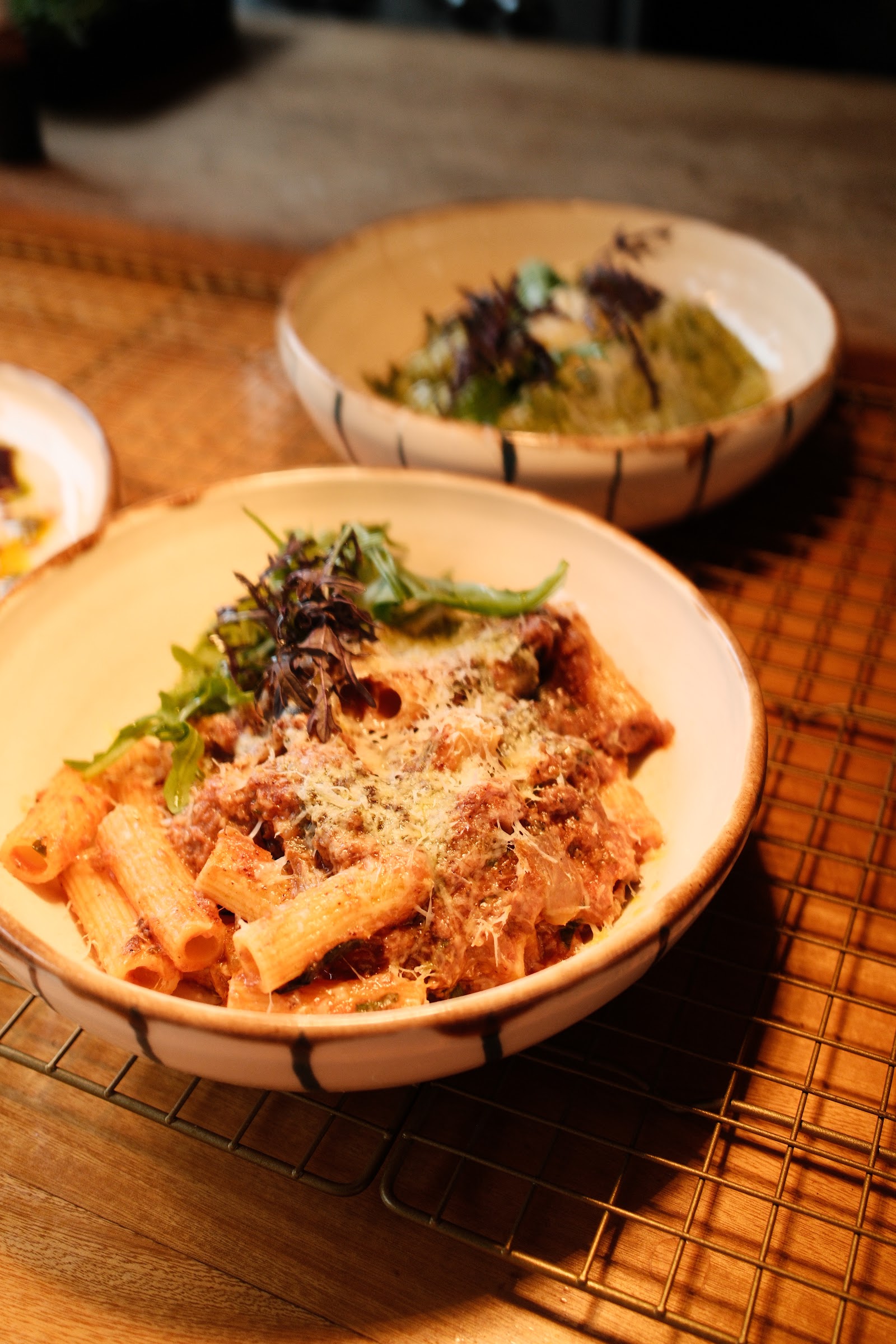 Rigatoni con salsa y queso rallado en plato artesanal