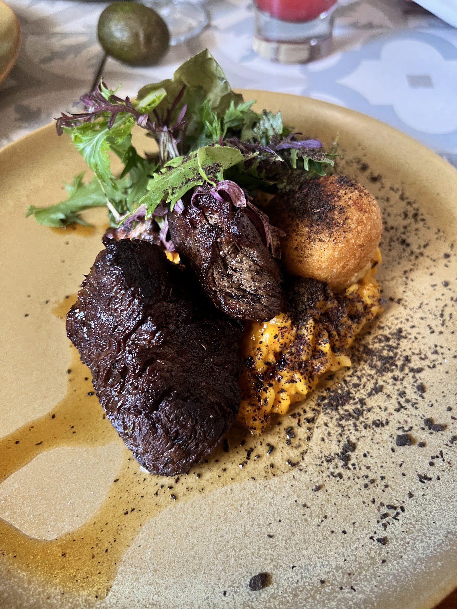Carne en salsa con croqueta y hojas frescas