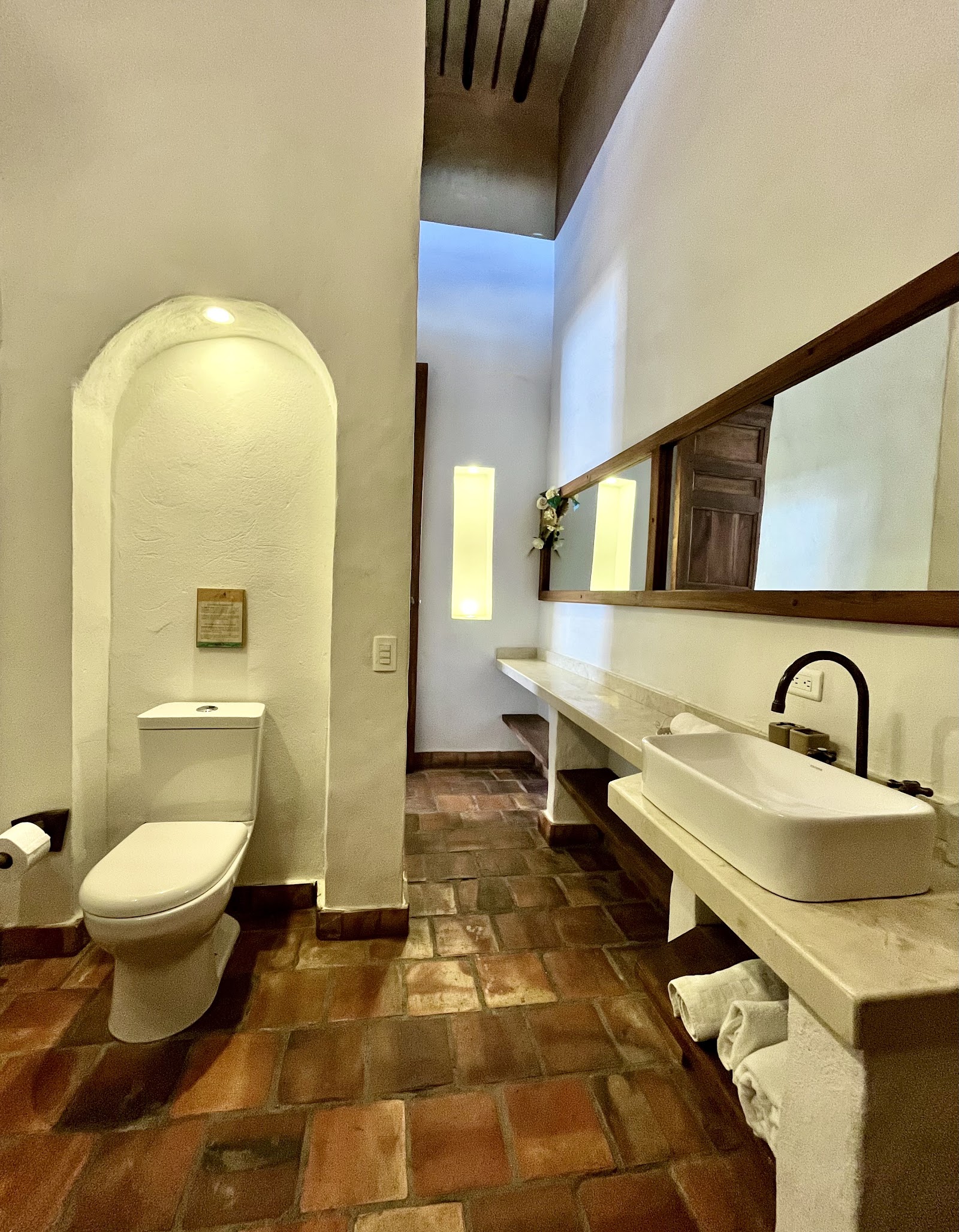 Baño con lavamanos de piedra y espejo largo