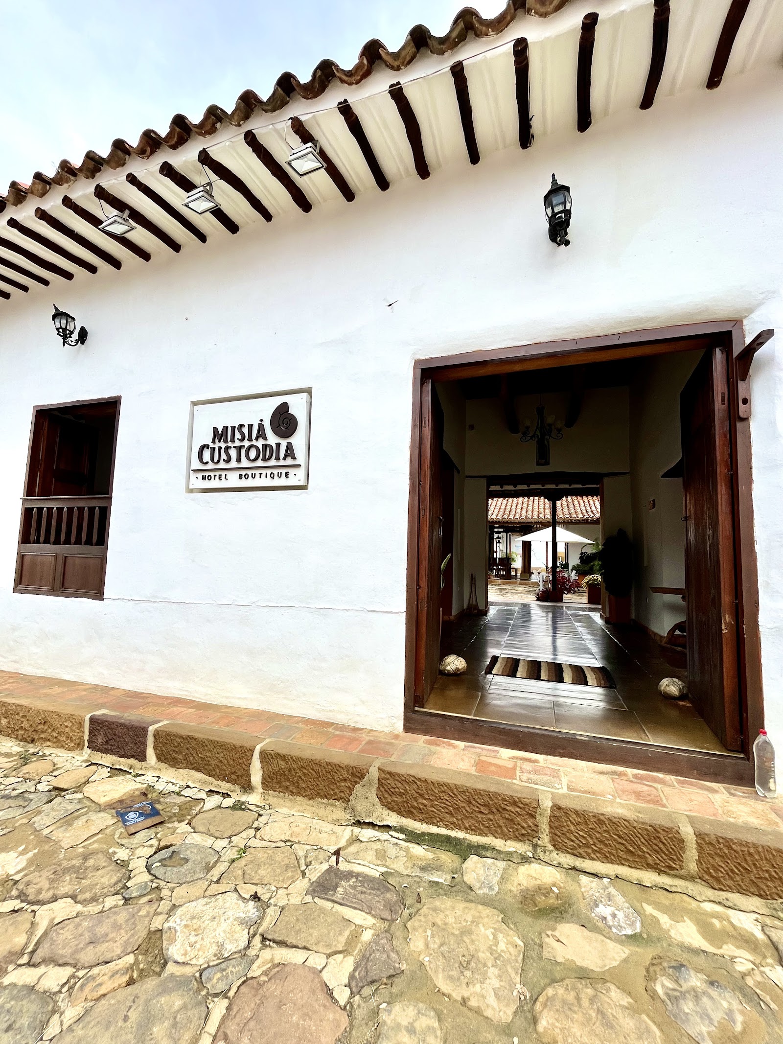 Fachada blanca de Misia Custodia sobre la calle empedrada de Guane