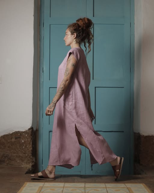 Vestido largo de lino palo de rosa frente a una puerta azul