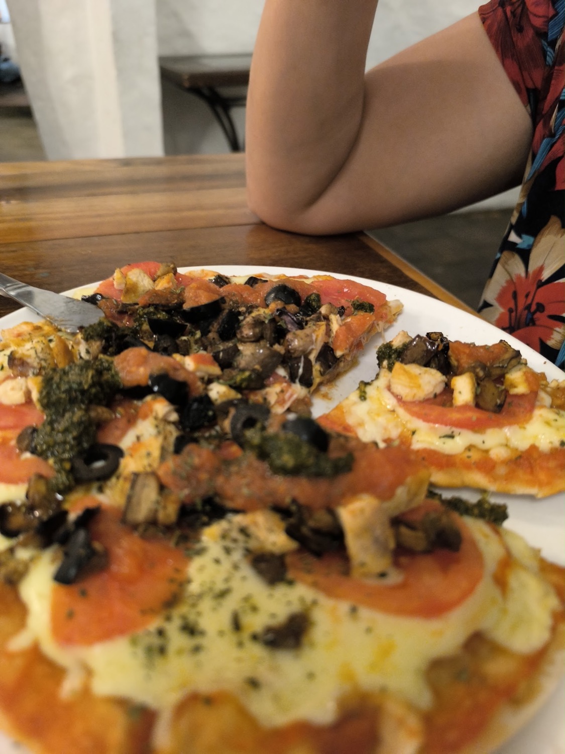 Pizza con aceitunas, champiñones, pesto y tomate