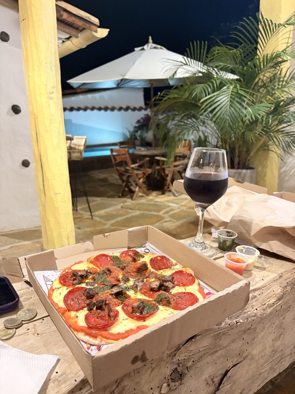 Copa de vino tinto y pizza en la terraza