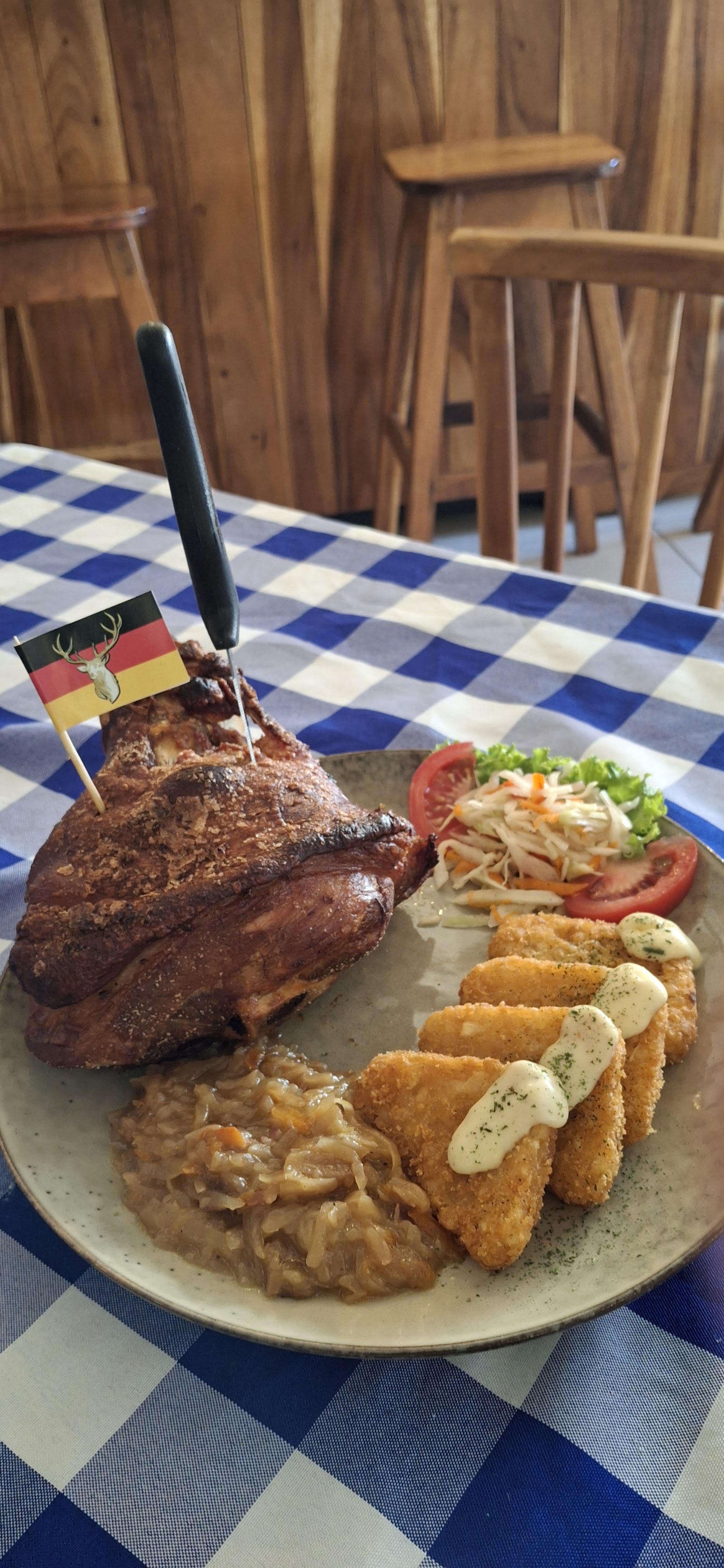 Plato de cerdo asado con banderita de Alemania y acompañamientos