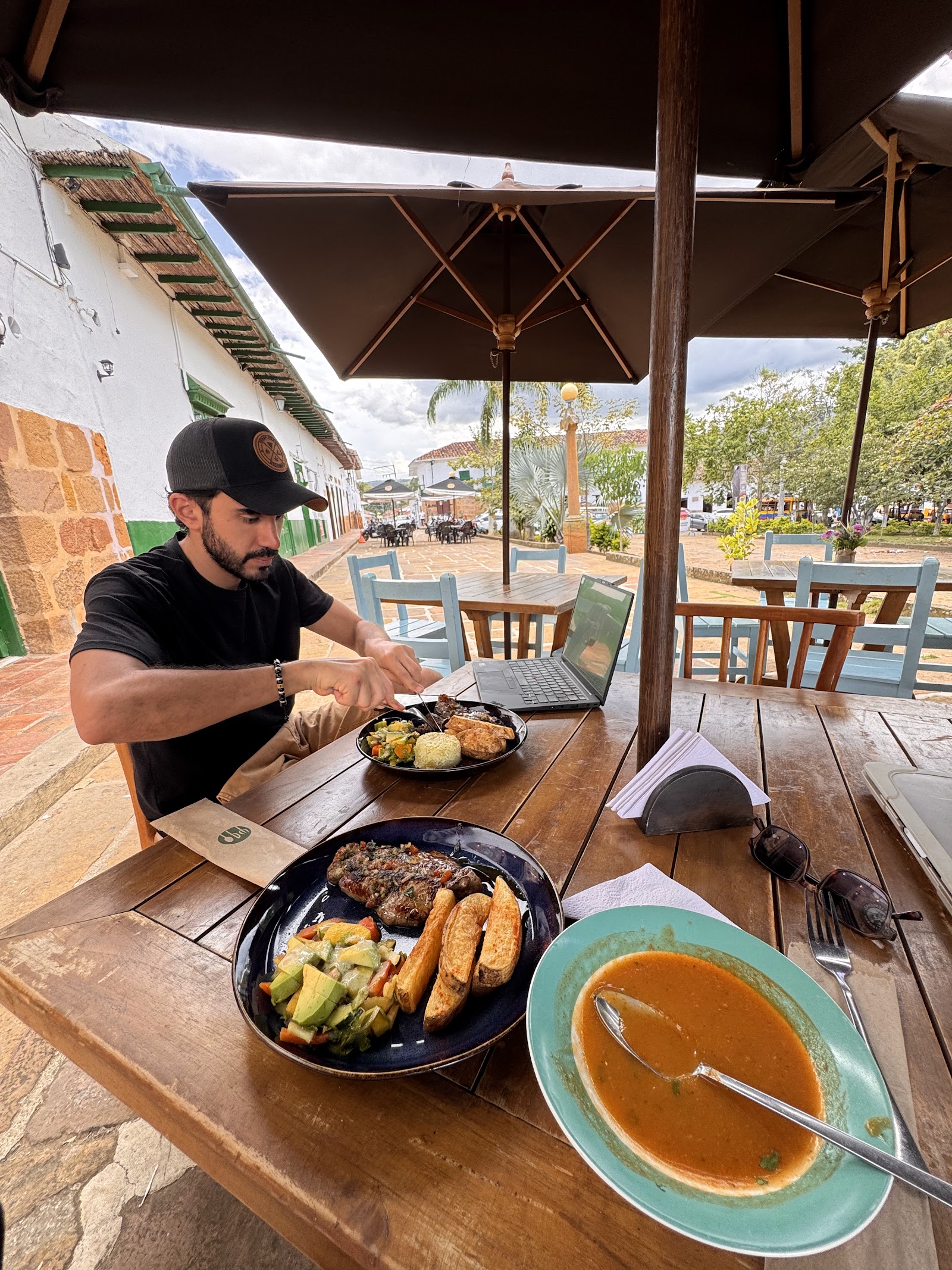 Comensal en la terraza bajo las sombrillas