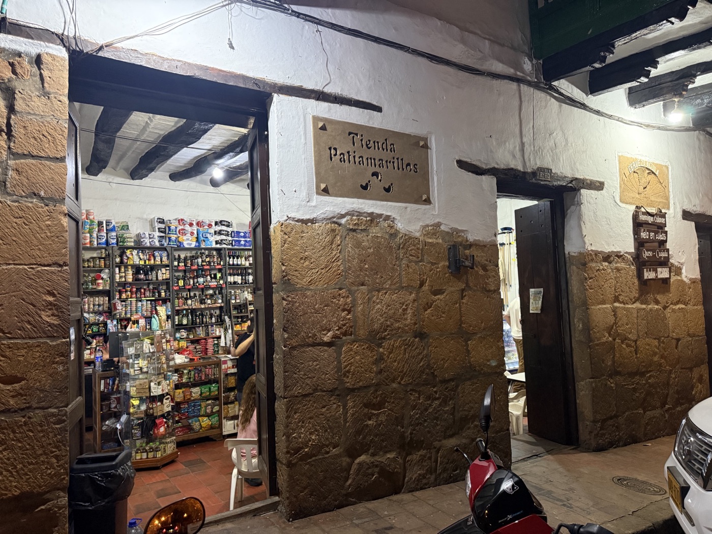 Entrada de la tienda con el letrero Tienda Patiamarillos sobre muro de piedra